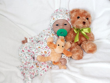 A baby doll with a pacifier placed on its head, showcasing a playful and whimsical design.